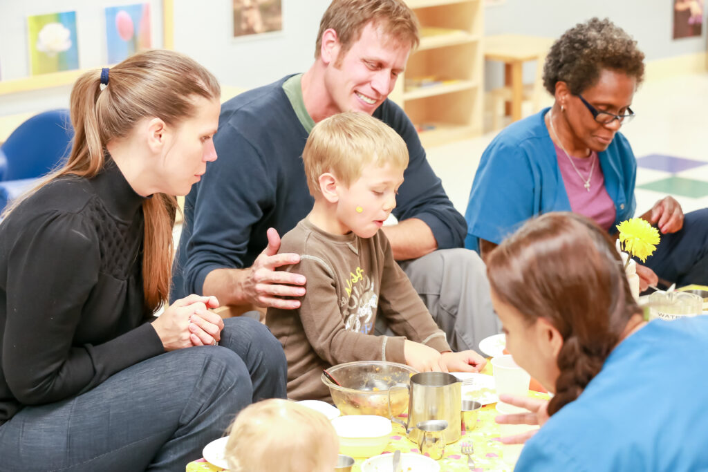 Parents and young children participating in a cooking class together.