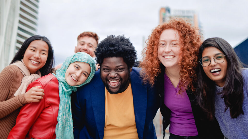 Multiracial happy group of friends having fun outdoors in the city