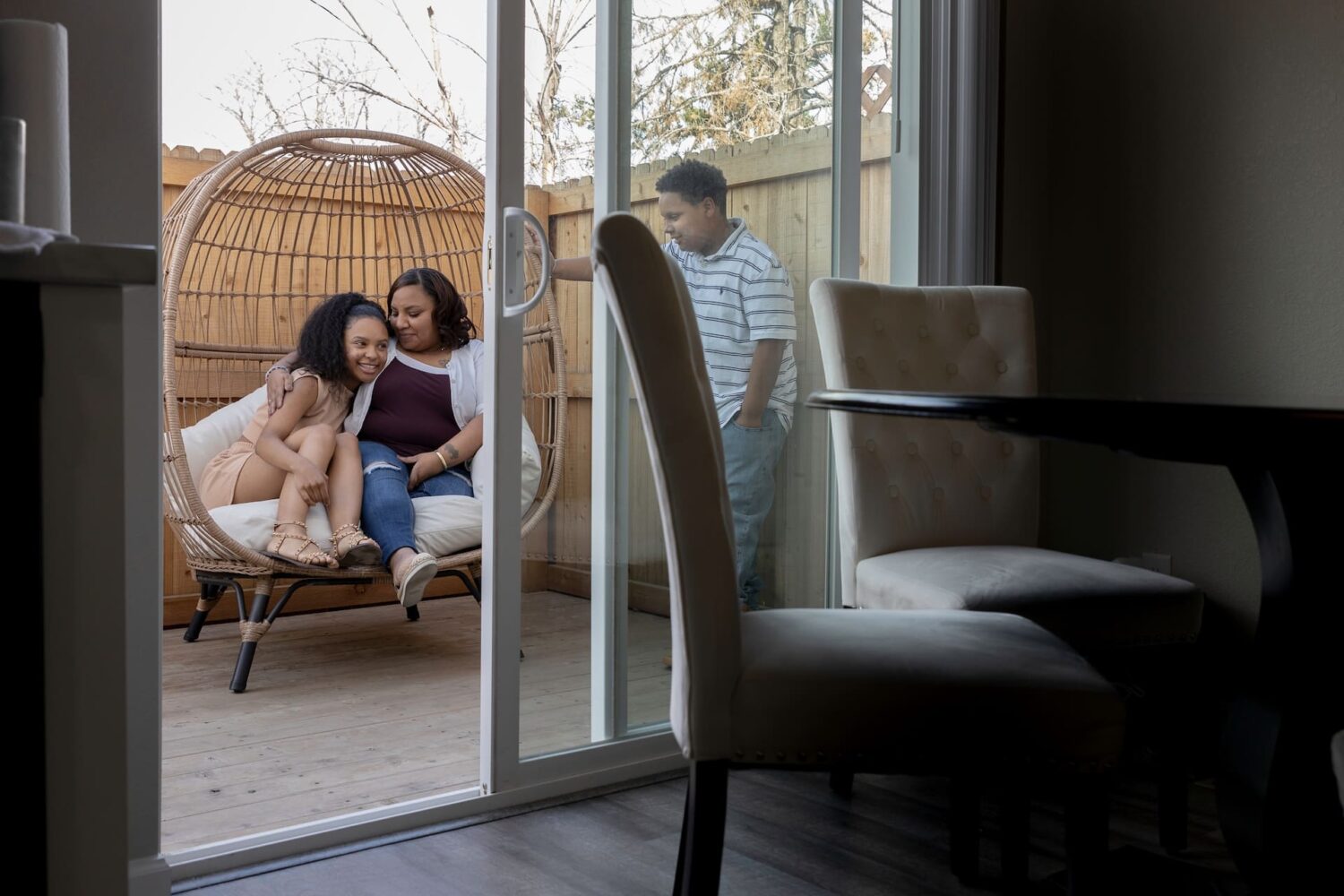 A mom and her two teen children spend time together on their patio