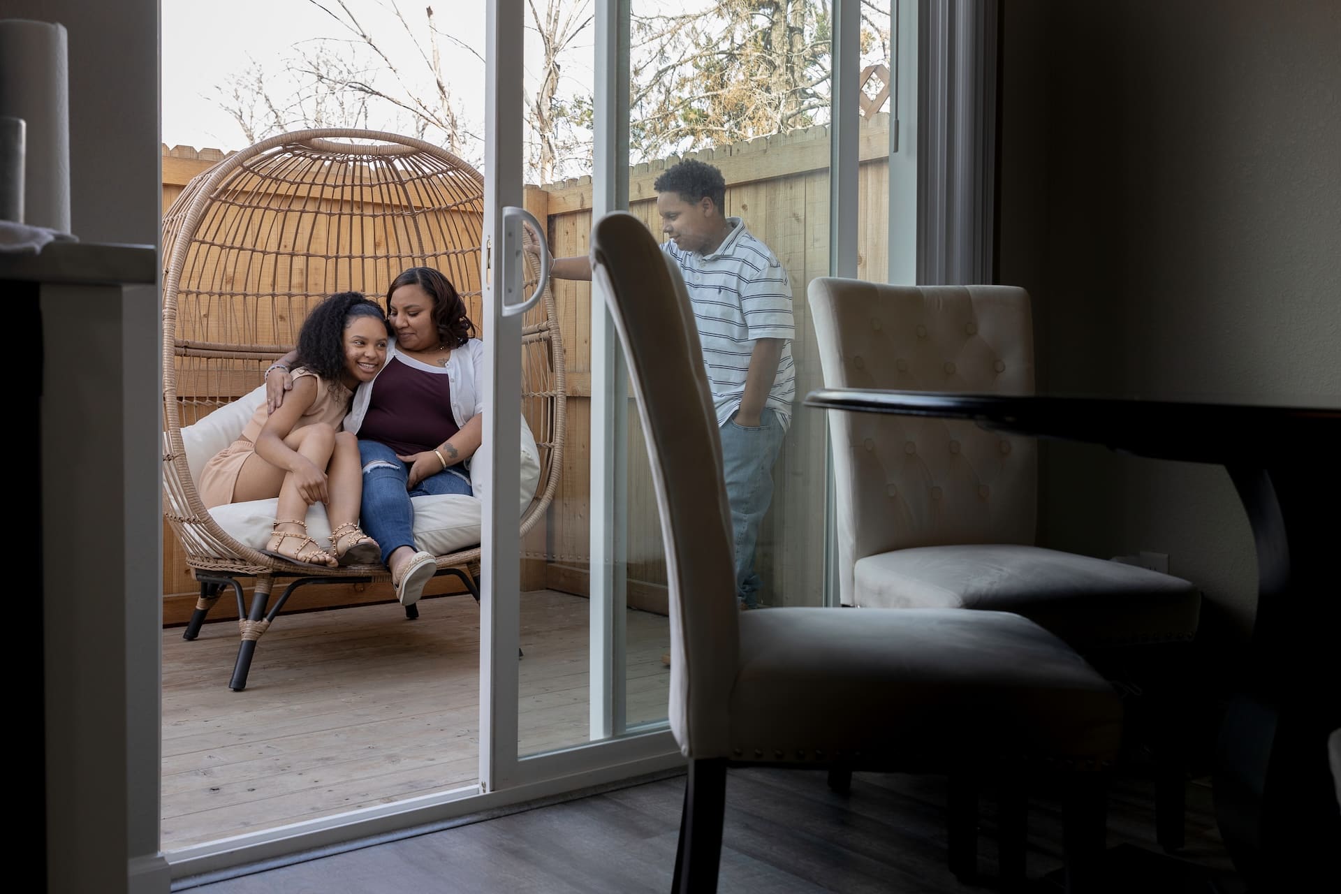 A mom and her two teen children spend time together on their patio